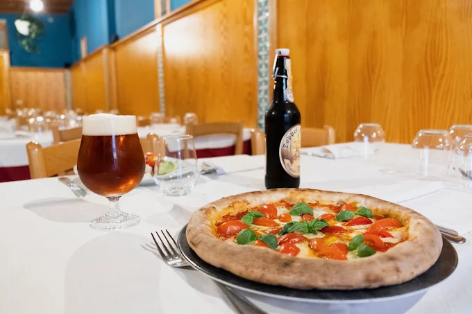 Pizza e birra servite al tavolo